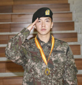 Soldier saluting with medal around neck.