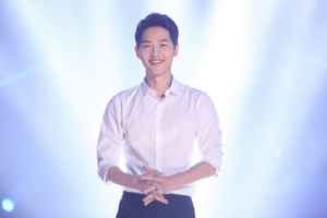 Smiling man in a white shirt on stage.