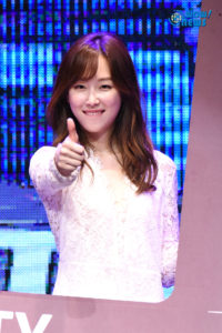 Smiling woman giving a thumbs up.