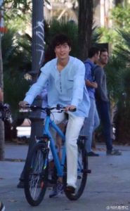 Person riding a blue bicycle outdoors.
