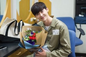 Smiling person in a uniform holding flowers.