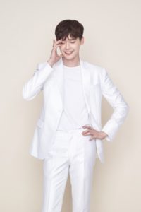 Smiling man wearing a white suit.