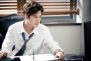 Young man focused at a desk with computer.