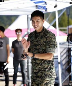 Smiling soldier waving at the camera.