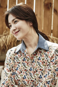 Smiling person wearing a colorful patterned shirt.