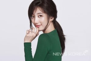 Smiling woman in green outfit, profile view.