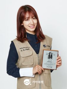 Smiling woman holding a framed certificate.