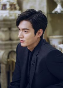 Young man in a black suit, profile view.