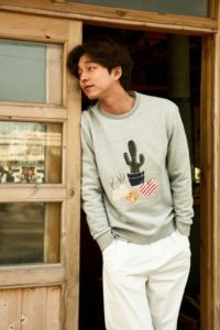 Man leaning against a wooden doorframe.