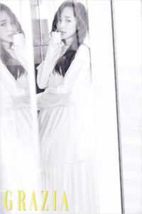 Woman in white dress by glass reflection.