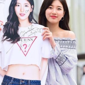 Person holding a signed poster while smiling.