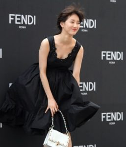 Woman in black dress at Fendi event.