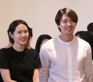Smiling couple in casual attire, happy atmosphere.