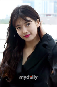 Young woman with long hair and bright lipstick.