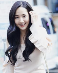 Smiling woman with long, wavy black hair.