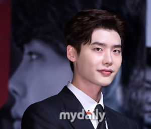 Young man in suit, smiling at event.