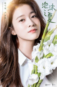 Woman holding white flowers, gazing softly.