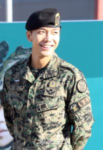 Smiling soldier in military uniform and beret.
