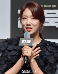 Woman speaking at a promotional event.