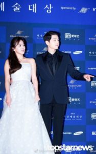 Couple posing at a formal event backdrop.