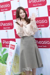 Woman waving in front of product display.