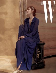 Elegant woman in blue dress, serene pose.