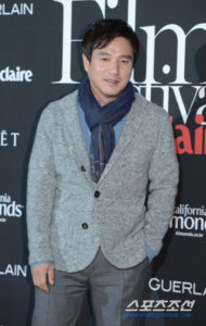 Man in cardigan at film festival event.