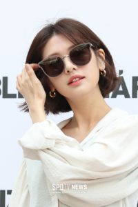 Person wearing sunglasses and white blouse.