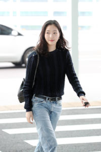 Woman walking in casual outfit at airport.