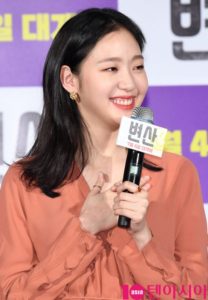 Smiling woman holding a microphone at event.