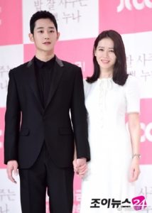 Two people holding hands at an event.