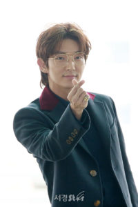 Person in stylish outfit making a gesture.