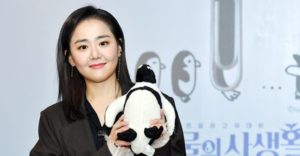 Person holding a penguin plush toy.