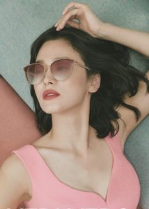 Woman wearing sunglasses in a pink outfit.