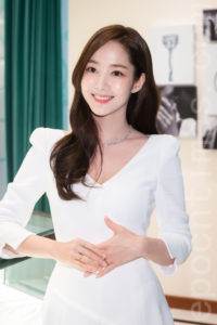 Smiling woman in elegant white dress.