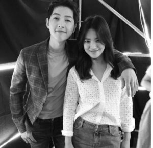 Smiling duo posing together in black and white.