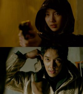 Woman and man pointing guns at each other.