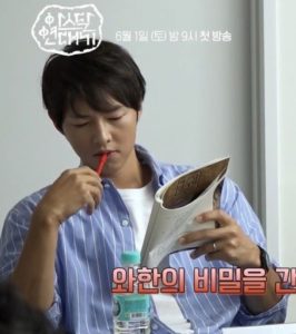 Person reading a book with a red pen.