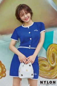 Woman in blue outfit against colorful background.