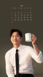 Person holding a mug beside a calendar.
