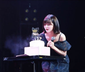 Person blowing out birthday candle on cake.