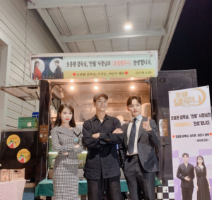 Three people posing in front of a food truck.
