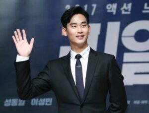 Man in suit waving at an event.