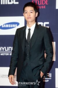 Man in suit at a red carpet event.