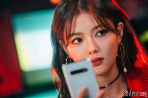 Young woman holding a smartphone, looking thoughtful.