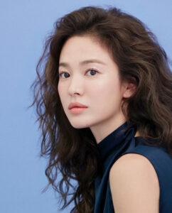 Woman with curly hair against blue background.