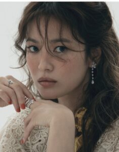 Woman with earrings and ring, gazing thoughtfully.