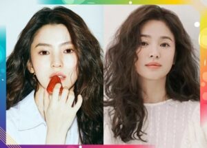 Two women with wavy hair, one holding strawberry.