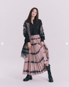 Woman in stylish outfit with pleated skirt.