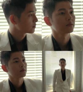 Man in a white suit, serious expression.